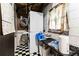 A laundry room with stacked washer/dryer, and black and white checkerboard flooring at 5791 Cobbrook Dr, Ellenwood, GA 30294