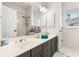 Bright bathroom featuring a double vanity, large mirror, and tub with shower at 1265 Timberline Pl, Alpharetta, GA 30005