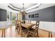 Elegant dining room with hardwood floors, a modern chandelier, and large windows providing natural light and backyard views at 1265 Timberline Pl, Alpharetta, GA 30005