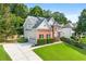 Beautiful two-story home with brick and gray siding, a lush green lawn, and mature trees offering shade and privacy at 1265 Timberline Pl, Alpharetta, GA 30005