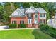 Charming two-story brick home with a manicured lawn, lush landscaping, and a welcoming light blue front door at 1265 Timberline Pl, Alpharetta, GA 30005