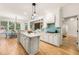 Bright, open kitchen with white cabinets, a kitchen island and an adjacent dining area, and hardwood floors at 1265 Timberline Pl, Alpharetta, GA 30005