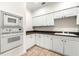 Kitchenette area with white cabinets, dark countertops, and modern appliances at 1265 Timberline Pl, Alpharetta, GA 30005
