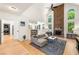 Bright living room with a stone fireplace, high ceilings, large windows, and comfortable seating with a view to the laundry room at 1265 Timberline Pl, Alpharetta, GA 30005