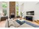 Bright living room with a stone fireplace, high ceilings, large windows, and comfortable seating with a view to the fireplace at 1265 Timberline Pl, Alpharetta, GA 30005