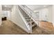Carpeted staircase with white railing, leading to an entryway with hardwood floors at 1265 Timberline Pl, Alpharetta, GA 30005