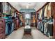 Spacious walk-in closet with custom shelving, hanging racks, and center ottoman at 1265 Timberline Pl, Alpharetta, GA 30005