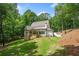 Manicured backyard featuring expansive lawn and a patio, surrounded by lush trees at 2585 Hickory Rd, Canton, GA 30115