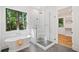 Stylish bathroom featuring a modern tub, glass-enclosed shower, and a bright window at 2585 Hickory Rd, Canton, GA 30115