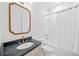 Elegant bathroom with a dark marble countertop, gold fixtures, and tiled shower with white curtain at 2585 Hickory Rd, Canton, GA 30115