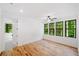Bright bedroom features hardwood floors, a ceiling fan, and three large windows overlooking a wooded area at 2585 Hickory Rd, Canton, GA 30115