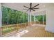 Expansive outdoor deck with wood flooring, ceiling fan, and railing, surrounded by lush greenery at 2585 Hickory Rd, Canton, GA 30115