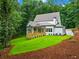 A charming home features a wooden deck, blending seamlessly into the lush, wooded landscape behind it with a well-manicured lawn at 2585 Hickory Rd, Canton, GA 30115