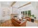 Bright living room boasts a stone fireplace, built-in shelving, hardwood floors, exposed beams and a view to the exterior at 2585 Hickory Rd, Canton, GA 30115