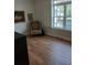 Bedroom with hardwood floors, a decorative chair, and a view of a window to the outside at 3655 Peachtree Rd # 203, Atlanta, GA 30319