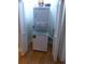 Stacked white washer and dryer laundry center in a small space with bi-fold doors and wood flooring at 3655 Peachtree Rd # 203, Atlanta, GA 30319