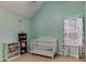 A Bedroom with pale green walls, white crib and Mickey Mouse curtains at 4150 Soaring Dr, Douglasville, GA 30135