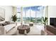 Bright living room with floor-to-ceiling windows showcasing city views, modern furniture, and hardwood floors at 4561 Olde Perimeter Way # 2102, Atlanta, GA 30346
