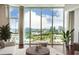 Light filled living room features floor-to-ceiling windows showcasing city views, comfortable furniture, and hardwood floors at 4561 Olde Perimeter Way # 2102, Atlanta, GA 30346