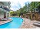 Inviting outdoor pool surrounded by trees, lounge chairs, and a stone wall with a relaxing pergola at 4561 Olde Perimeter Way # 2102, Atlanta, GA 30346