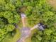 Aerial view of homes nestled in a lush green neighborhood with mature trees and circular driveways at 130 Opal Ln, Carrollton, GA 30116