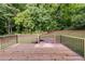 New wooden deck with black metal railings offering serene views of a lush wooded backyard at 130 Opal Ln, Carrollton, GA 30116