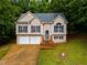 Charming two-story home with a well-manicured lawn, two-car garage, and inviting front porch at 130 Opal Ln, Carrollton, GA 30116