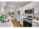 Modern kitchen featuring white cabinets, stainless steel appliances, and quartz countertops at 130 Opal Ln, Carrollton, GA 30116