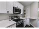 Well-lit kitchen with sleek white cabinetry, stainless steel appliances, and a functional layout at 130 Opal Ln, Carrollton, GA 30116