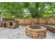Large backyard features a stone fire pit, outdoor kitchen, seating, and wooden privacy fence at 1605 Wellswood Se Dr, Atlanta, GA 30315