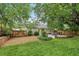 Green backyard featuring a stone fire pit, outdoor kitchen, lush trees, and landscaping at 1605 Wellswood Se Dr, Atlanta, GA 30315