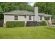 Exterior view of a single story home with a gray chimney, landscaped yard, and inviting front porch at 1605 Wellswood Se Dr, Atlanta, GA 30315