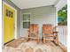 Inviting front porch with a bright yellow door and comfortable rocking chairs at 1605 Wellswood Se Dr, Atlanta, GA 30315