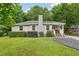 Inviting single-story home with a stone chimney, attractive landscaping, and a cozy covered porch at 1605 Wellswood Se Dr, Atlanta, GA 30315