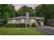 Charming single-story home with a well-manicured lawn, gray chimney, and cozy front porch at 1605 Wellswood Se Dr, Atlanta, GA 30315