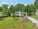 Charming single-story home with a well-manicured lawn, a paved driveway, and blossoming flower beds at 1605 Wellswood Se Dr, Atlanta, GA 30315
