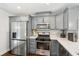Updated kitchen featuring stainless steel appliances and grey cabinets with solid surface counters and hardwood floors at 1605 Wellswood Se Dr, Atlanta, GA 30315