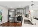 Updated kitchen featuring stainless steel appliances and grey cabinets with solid surface counters and hardwood floors at 1605 Wellswood Se Dr, Atlanta, GA 30315