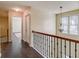 Hallway featuring hardwood floors, a decorative chandelier, and a view of the staircase and window at 1761 Stoney Chase Dr, Lawrenceville, GA 30044