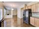 Open-concept kitchen with hardwood floors, wooden cabinets, and stainless steel refrigerator at 1761 Stoney Chase Dr, Lawrenceville, GA 30044