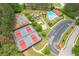 Aerial view featuring tennis courts, a playground, and a pool, surrounded by lush greenery and well-maintained landscaping at 285 Turtle Rock Pl, Acworth, GA 30101