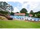 Community pool with lounge chairs and umbrellas, ideal for relaxation and recreation in a picturesque setting with lush landscaping at 285 Turtle Rock Pl, Acworth, GA 30101