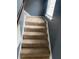 Carpeted staircase with white trim, window, and dark gray wall, ascending into the home at 4701 Flat Shoals Rd # 65A, Union City, GA 30291