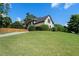 Well-manicured front yard with lush green grass, mature trees, and driveway leading to a two-car garage at 503 Chatfield Nw Way, Marietta, GA 30064