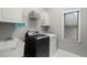 Well-lit laundry room with modern washer and dryer and storage shelving at 503 Chatfield Nw Way, Marietta, GA 30064