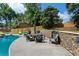 Relaxing backyard oasis with a pristine pool, stone retaining wall, built in gas grill, and outdoor dining area at 503 Chatfield Nw Way, Marietta, GA 30064