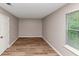 A bright bedroom featuring new floors and a large window overlooking a wooded view at 5290 Forest Downs Ln, Atlanta, GA 30349