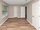 Spacious bedroom with new floors, three doors, and a window with blinds at 5290 Forest Downs Ln, Atlanta, GA 30349