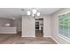 Open dining room looking into the kitchen with modern lighting and flooring at 5290 Forest Downs Ln, Atlanta, GA 30349