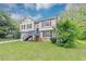 Charming two-story home with a stone foundation, gray siding and mature trees at 5290 Forest Downs Ln, Atlanta, GA 30349